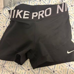 These are Nike pro shorts in black with white letters in a size medium.